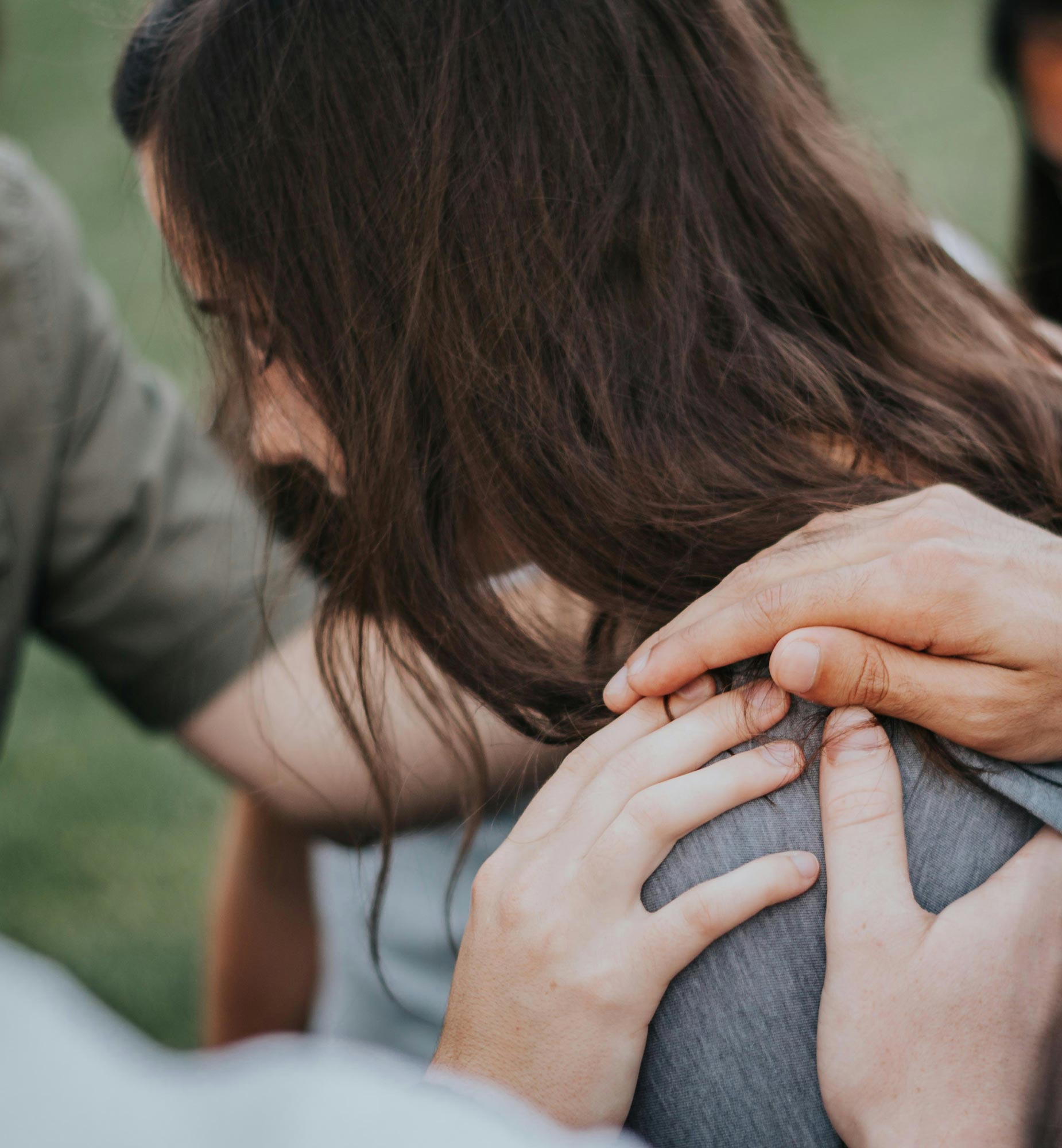 Group of People Laying Hands on Woman in Prayer